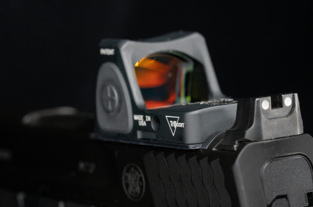 Advances in Firearm Materials and Design: A Complete Guide (2026) 5 Trijicon RMR red-dot pistol optic mounted on a Smith & Wesson M&P 2.0 — the optic revolution that doubled hit probability at distance