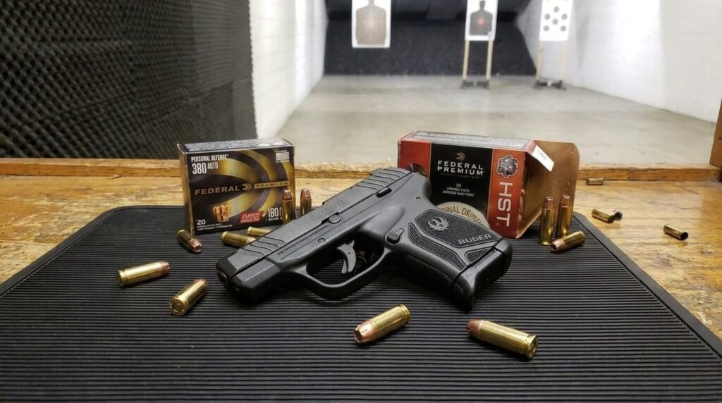 .380 ACP vs 9mm: Which Should You Carry? (2026) 29 Ruger LCP II .380 ACP pistol on an indoor range bench with Federal 380 and HST defensive ammunition