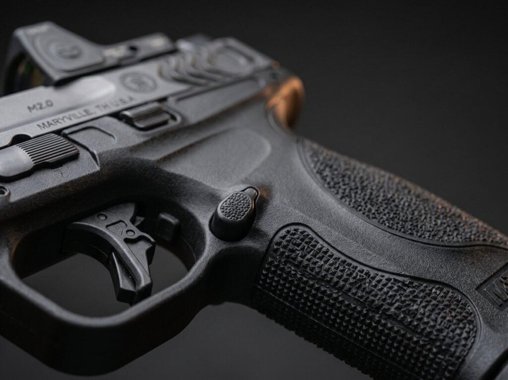 S&W M&P 9 M2.0 Full-Size Review (2026): 500 Round Test of the Duty-Grade 9mm 3 Macro close-up of the Smith and Wesson M&P 9 M2.0 aggressive cube-pattern grip stippling, polymer grip, flat-face trigger and slide-mounted optic with M2.0 Maryville TN rollmark visible