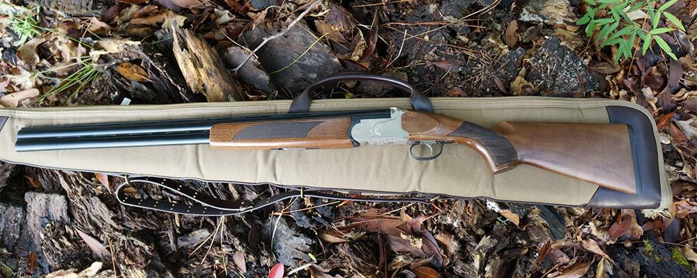 8 Best Over/Under Shotguns Under $1,000 in 2026 14 Mossberg Silver Reserve II over and under shotgun in a tan canvas rifle case on a bed of autumn leaves and mossy logs in dappled forest light