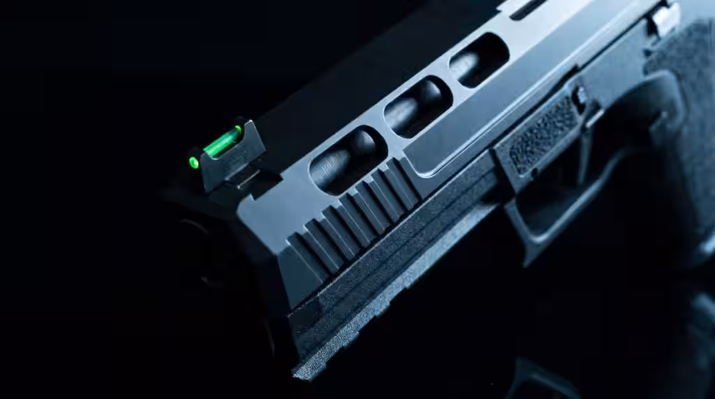 PSA 5.7 Rock Review: 800 Round Test of the Most Affordable 5.7 Pistol (2026) 9 Extreme macro close-up of the PSA 5.7 Rock showing the vivid green fiber optic front sight dot, three slide cutout windows, and two-tone slide serrations in cool blue-white LED side-rim light against deep black studio background