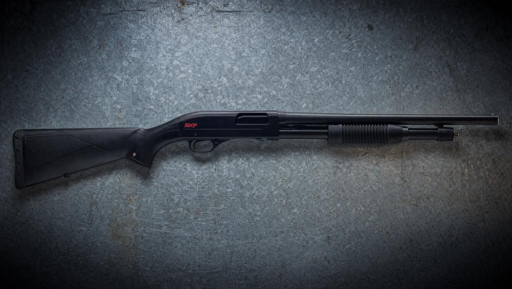 10 Best Shotguns for Home Defense (2026): Tried and Tested 20 Winchester SXP Defender 12 gauge pump shotgun left side profile on weathered galvanized steel workbench under cool overhead light
