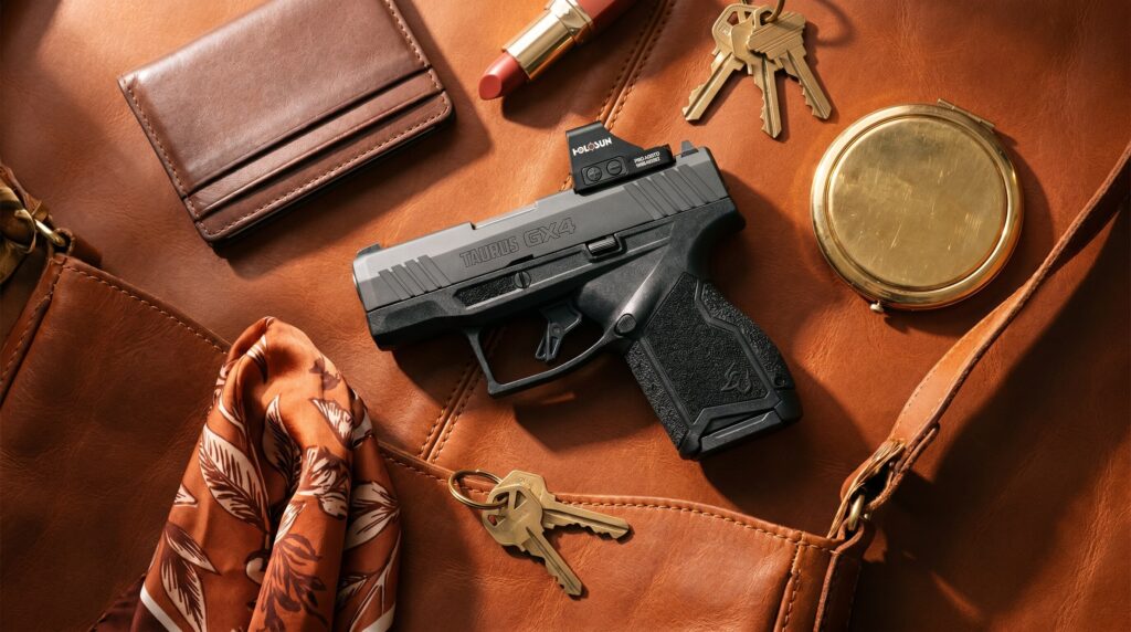 Best Guns Under $400 for Women (2026): Budget Self-Defense Picks 10 Taurus GX4 micro-compact 9mm pistol arranged on a hand-stitched cognac leather purse interior with brown bifold wallet, warm-red lipstick, brass house keys, silk pocket scarf, and vintage gold compact mirror in warm overhead café-window daylight