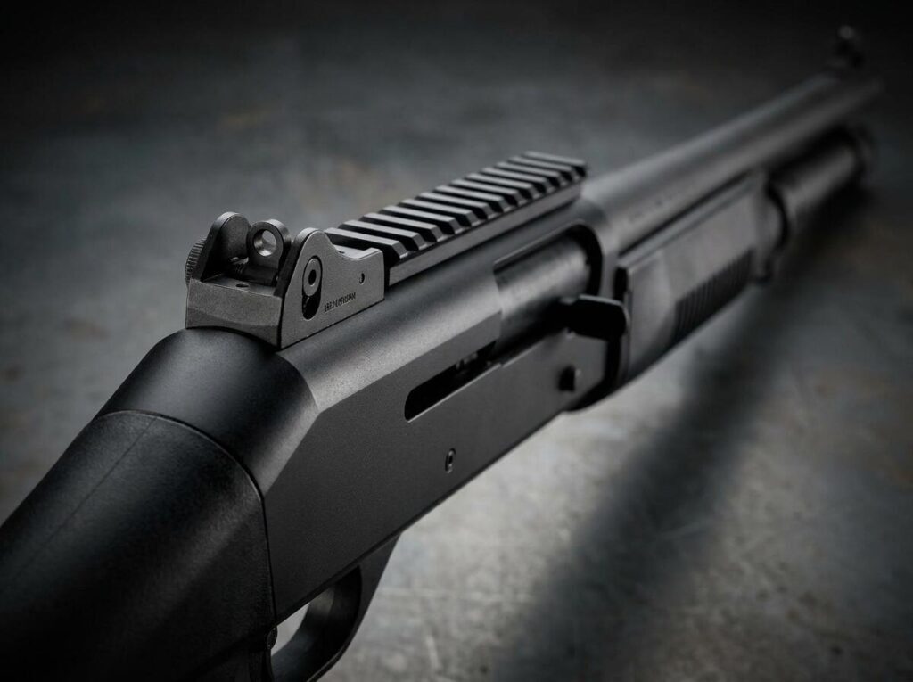 Benelli M4 vs Mossberg 590: Which Defensive Shotgun? (2026) 10 Macro detail of the Benelli M4 receiver, rail and ghost-ring rear sight