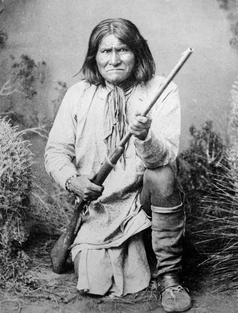 8 Famous Gun Photos and the Stories Behind Them 3 Geronimo, 1887. The defiant warrior is kneeling on a studio set.