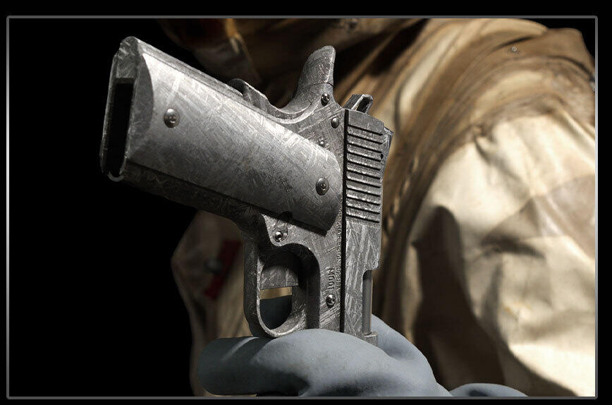 Bligh Guns Forges a 1911 From 4-Billion-Year-Old Meteorite Iron 5 Front view of the Bligh Guns Meteorite 1911 held in a gloved hand with serial number M001 visible on the frame