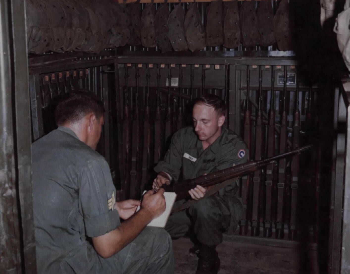 US Army soldiers inventory racked M14 rifles in an arms room