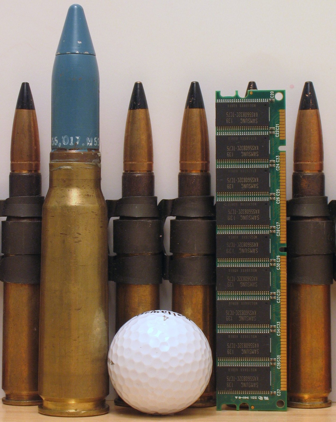 10 Firearms Myths People Still Believe (and the Truth Behind Them) 6 A .50 BMG cartridge beside 7.62 rifle rounds, a golf ball and a memory module for scale