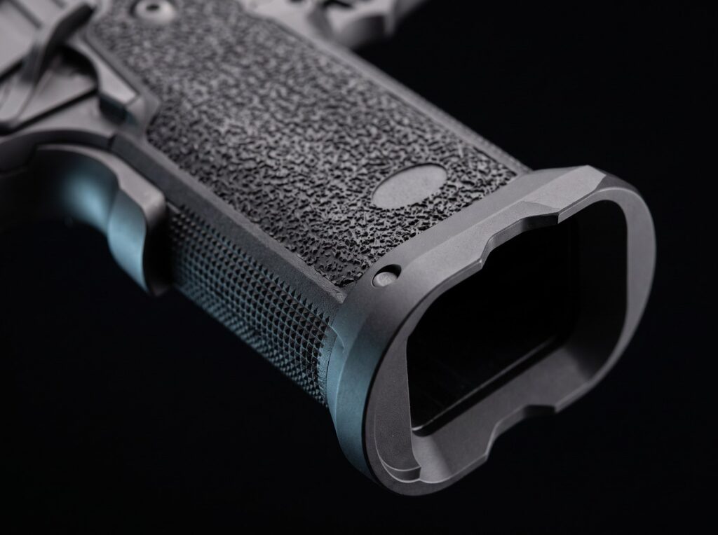 Macro detail of the Bul Armory SAS II flared magwell and stippled grip panel