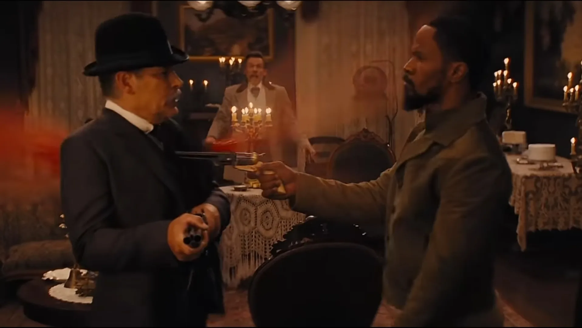 Django holding Mr Pooch at gunpoint with a brass-framed percussion revolver in Django Unchained