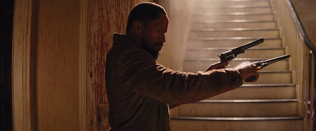Django dual-wielding a Colt 1851 Navy and a Remington New Army during the Candyland shootout in Django Unchained