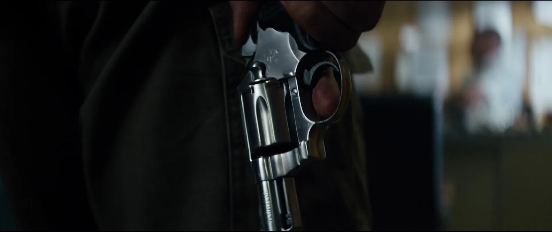 Close-up of Frank Masters cocking his Colt Detective Special revolver with Mag-na-port cuts in the barrel in The Equalizer