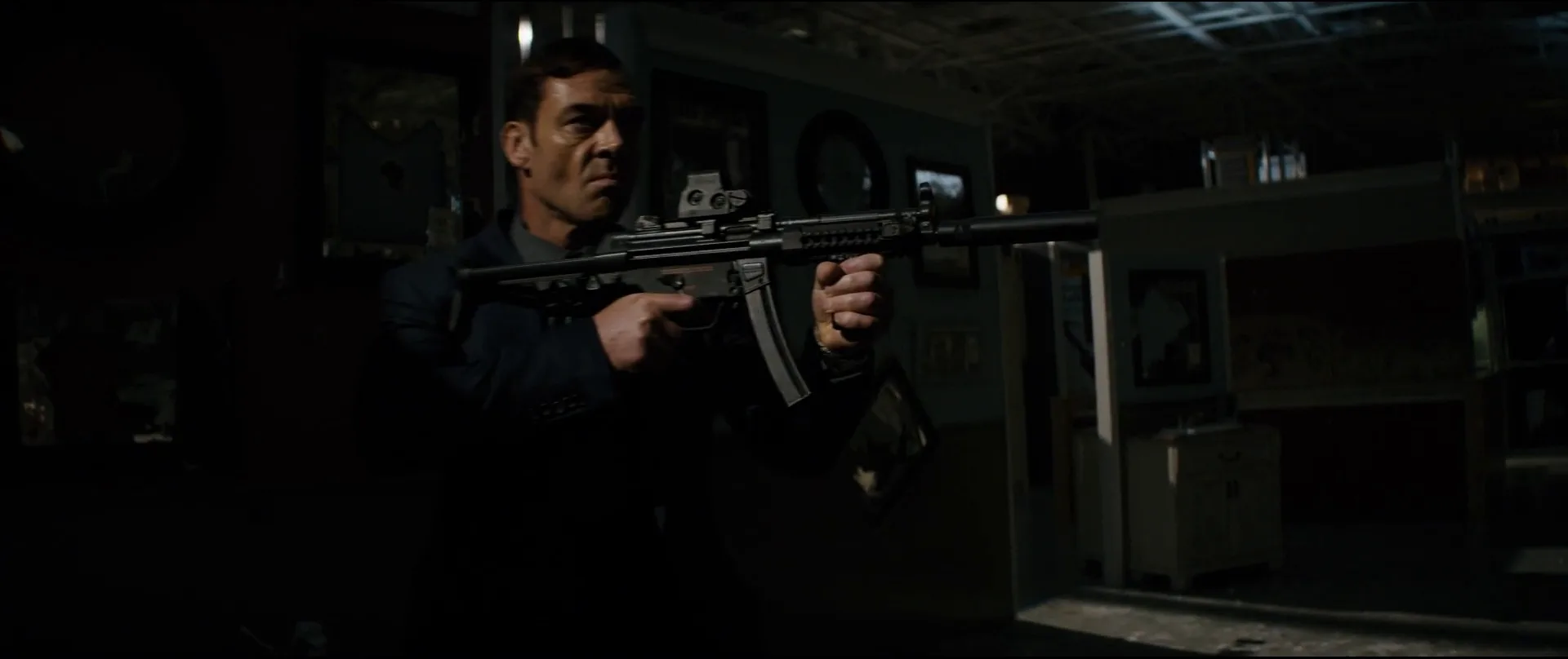 Teddy Rensen shouldering a suppressed Heckler and Koch MP5A3 with an EOTech sight in the Home Mart in The Equalizer