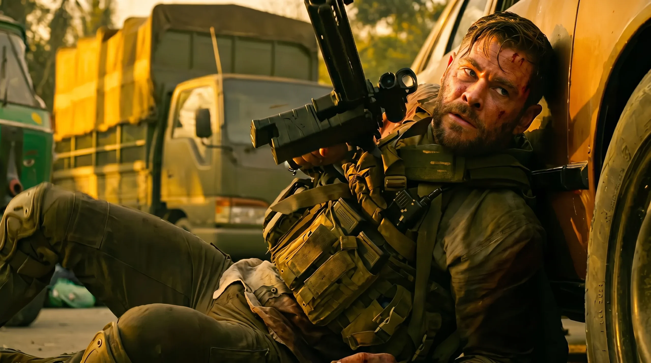 Tyler Rake seated beside a truck with his suppressed BCM CQB-11 carbine in Extraction