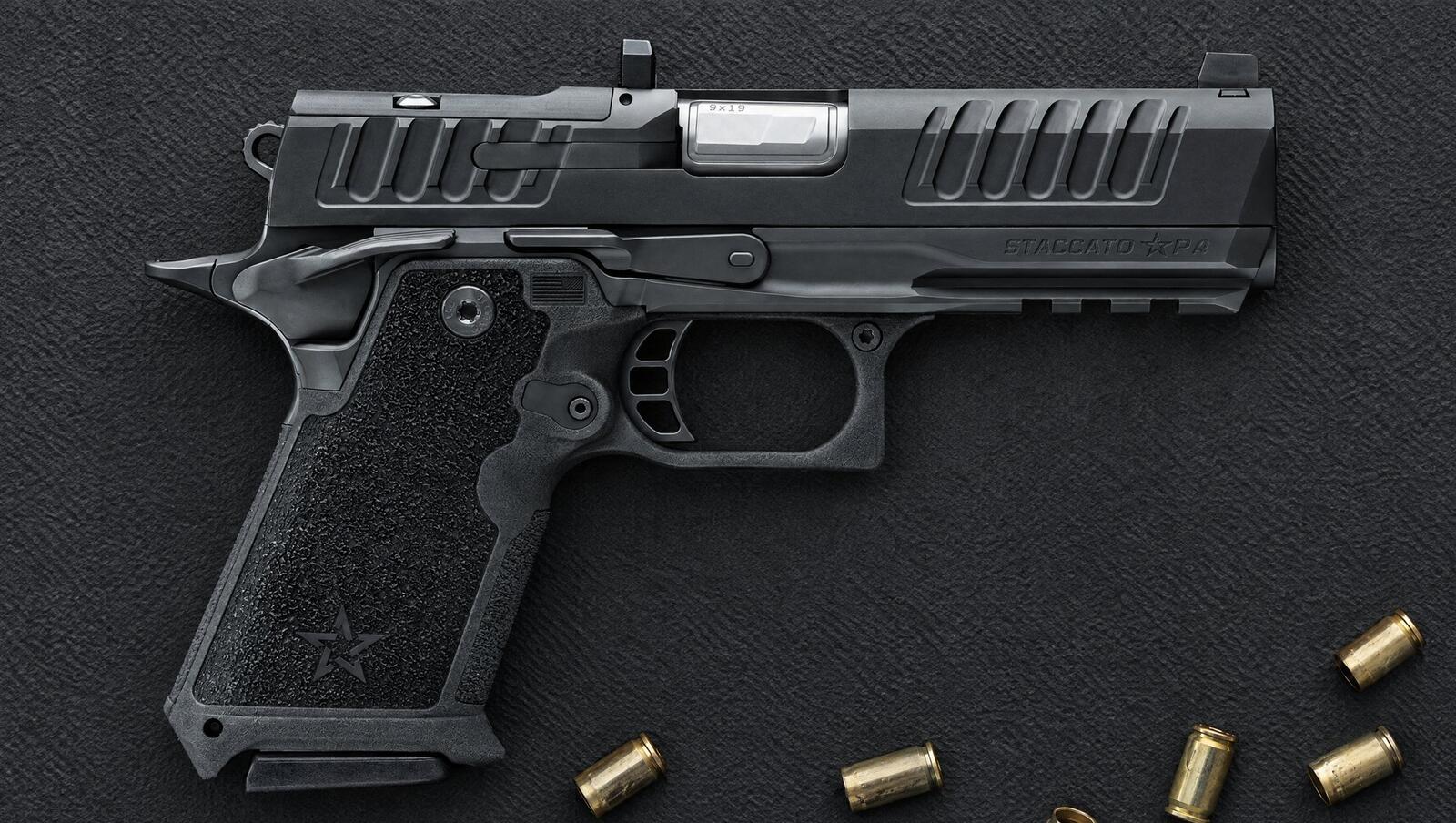 Staccato HD P4 2011 pistol lying on a black rubber range mat with spent 9mm brass