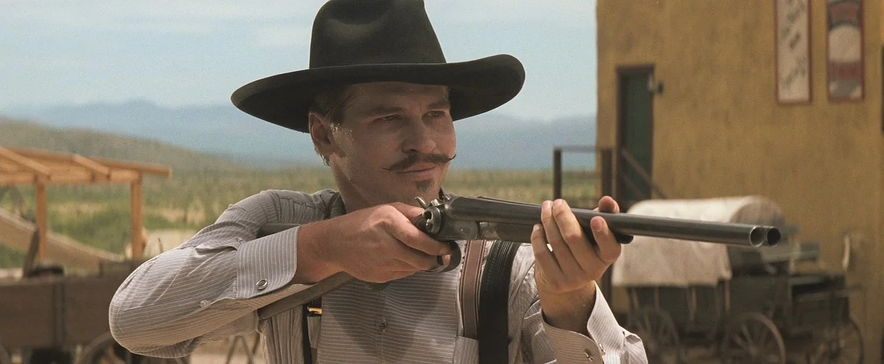 Doc Holliday shouldering a 10-gauge side-by-side shotgun at the O.K. Corral in Tombstone