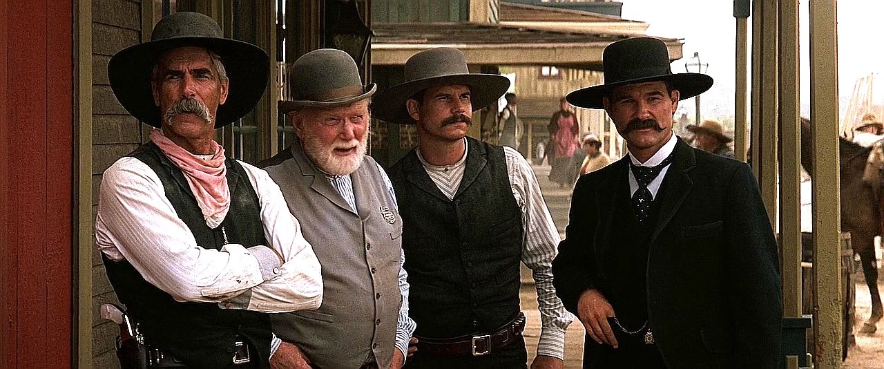 Virgil Earp standing with a pearl-gripped Smith and Wesson New Model No. 3 in his holster beside the other Earps in Tombstone