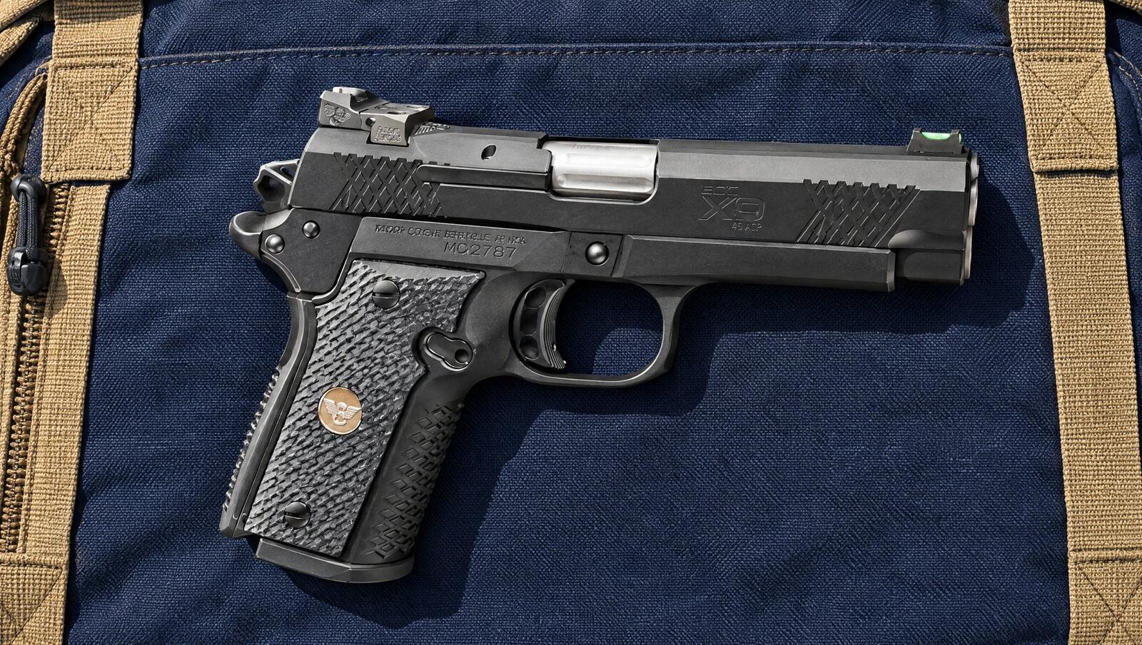 Wilson Combat EDC X9 2.0 pistol lying on a navy canvas range bag in morning sun