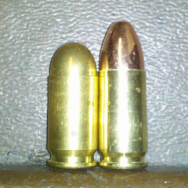 A 9x18 Makarov cartridge beside a longer 9mm Luger cartridge, both with full metal jacket bullets