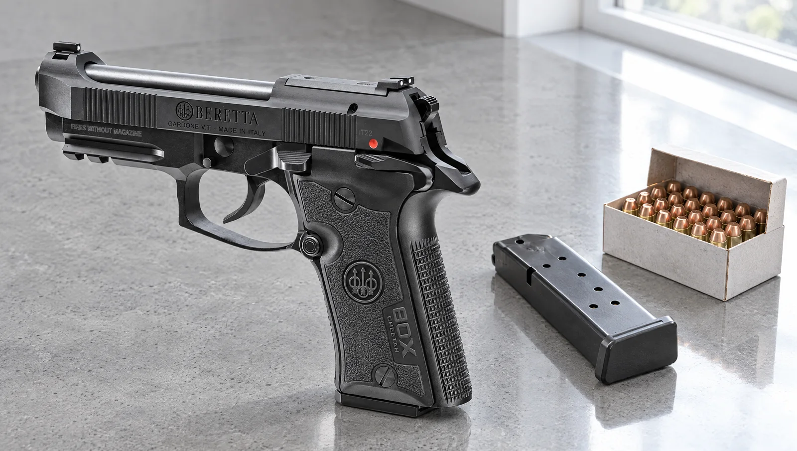 Beretta 80X Cheetah pistol on a gray concrete countertop beside a spare magazine and a box of .380 cartridges