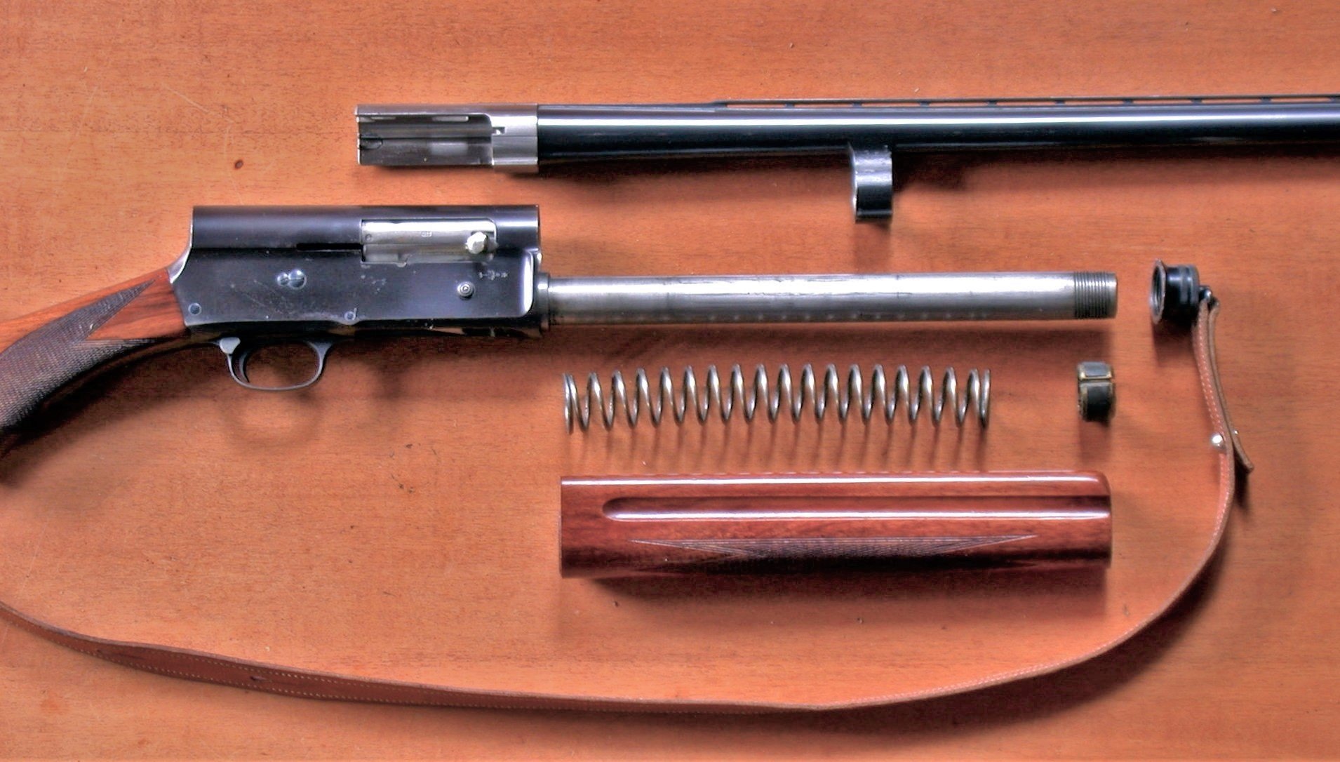 Field-stripped Browning Auto-5 showing barrel, magazine tube, recoil spring, friction ring and forearm