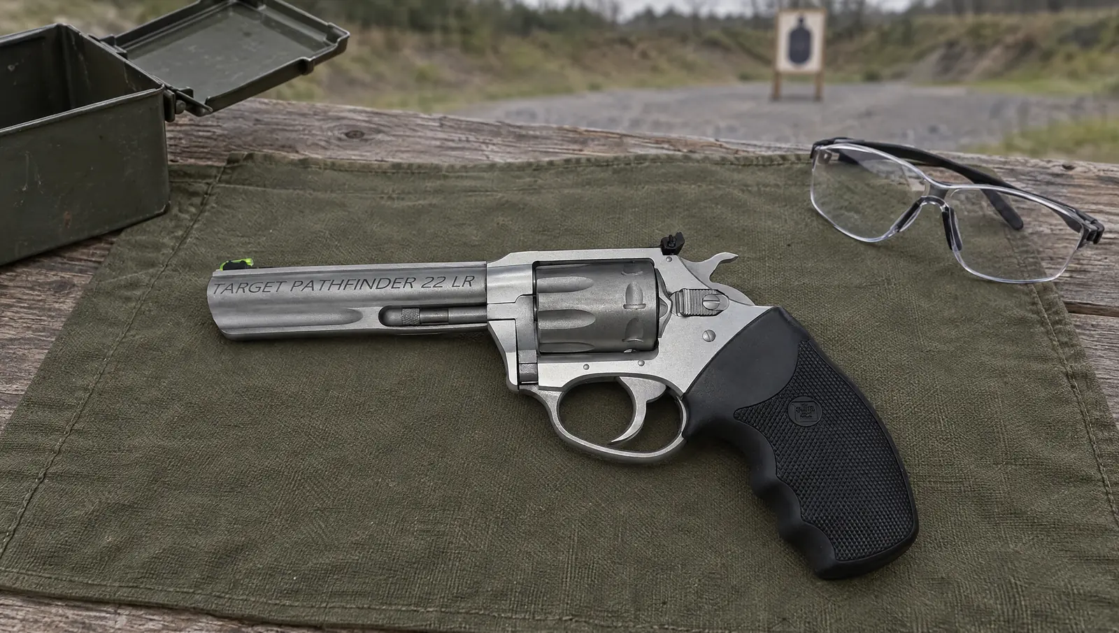Charter Arms Target Pathfinder 22 LR revolver with a 4.2 inch barrel and fiber optic front sight lying on a green canvas mat at an outdoor pistol range