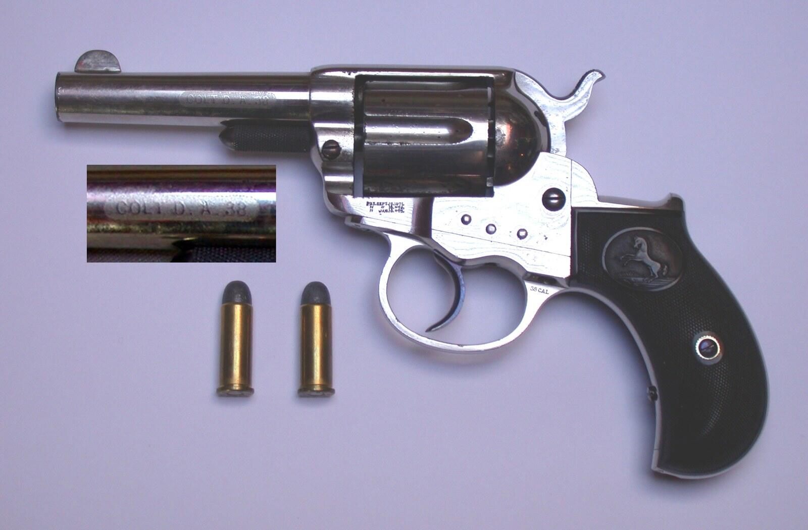Nickel-plated Colt Model 1877 Lightning double-action revolver with bird-head grip and two cartridges