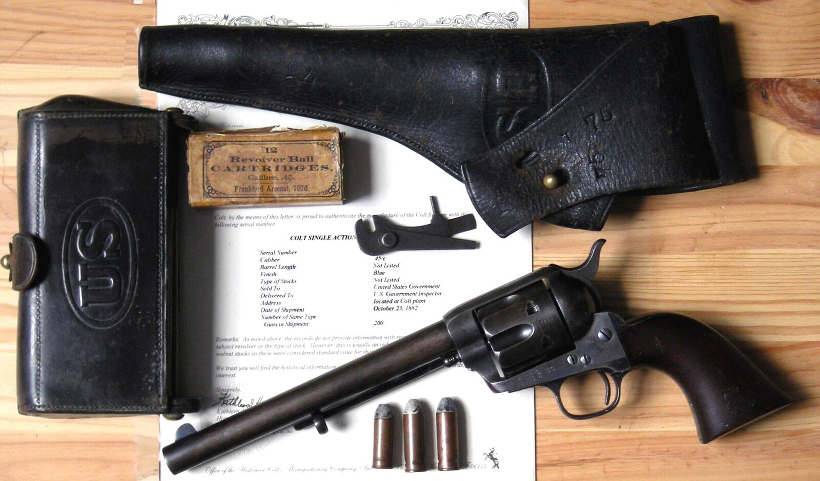 Antique Colt Single Action Army revolver with a holster and cartridges