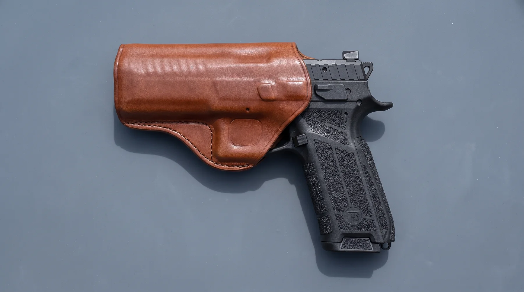 CZ P-09 F Nocturne 9mm seated in a brown leather holster on a gray shooting mat, seen from above