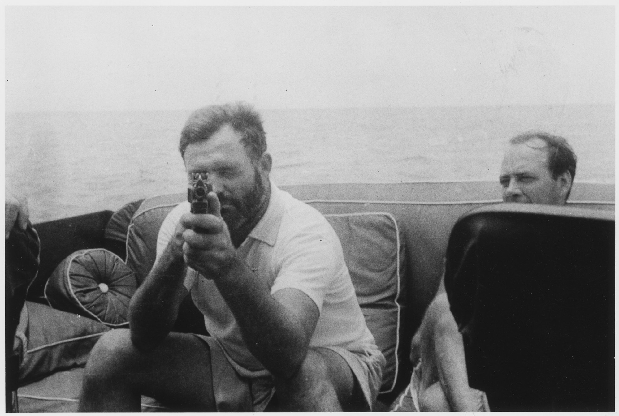Ernest Hemingway aiming a pistol aboard his fishing boat Pilar in 1935