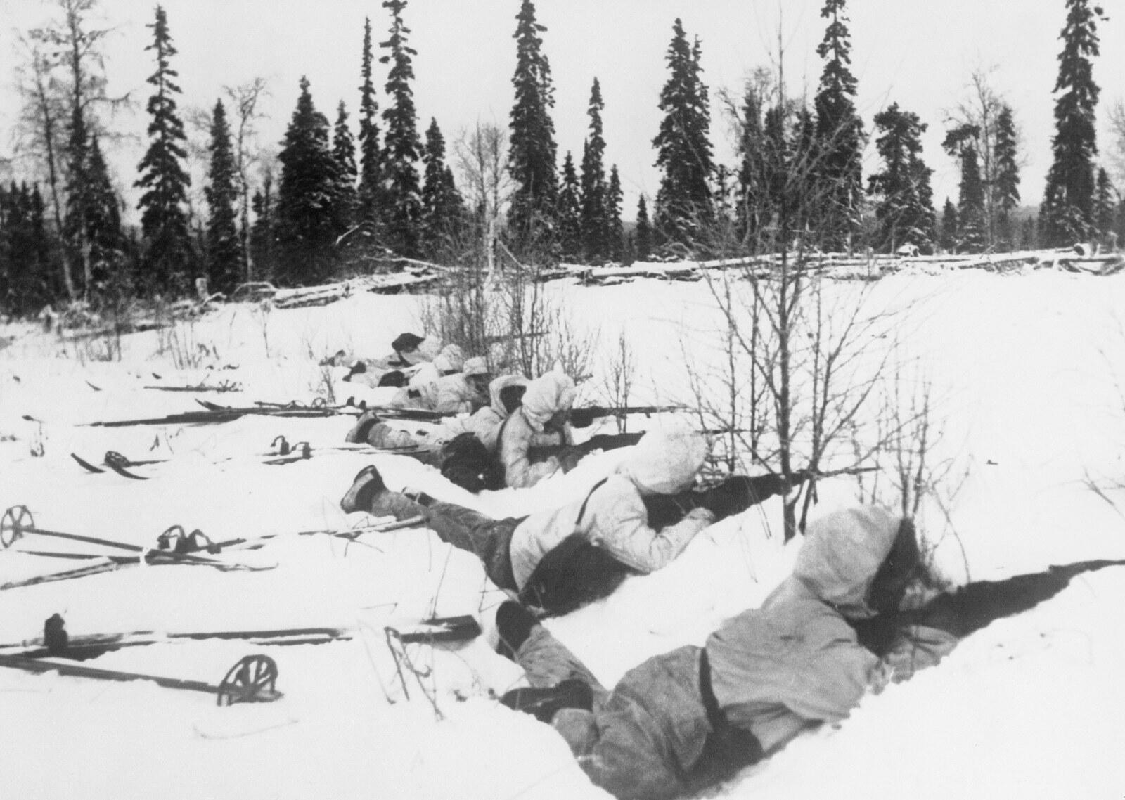 Finnish ski patrol in white camouflage lying in the snow at the edge of a forest, January 1940