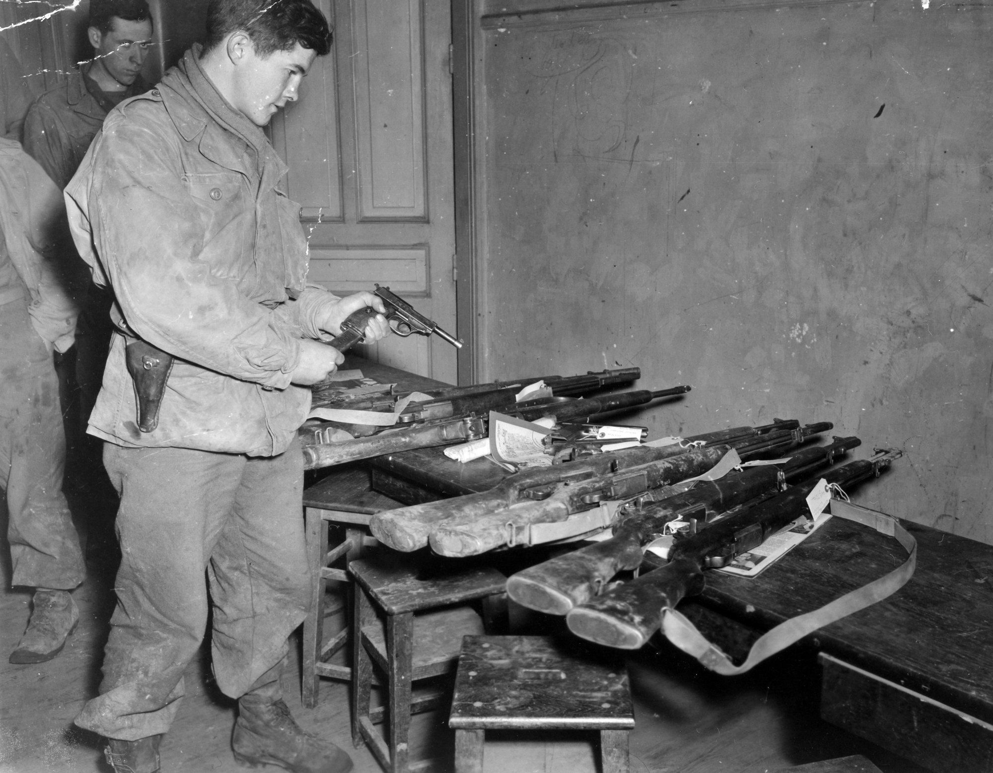 US Army staff sergeant loading a magazine into a captured Walther P38 in Nancy, France, December 1944