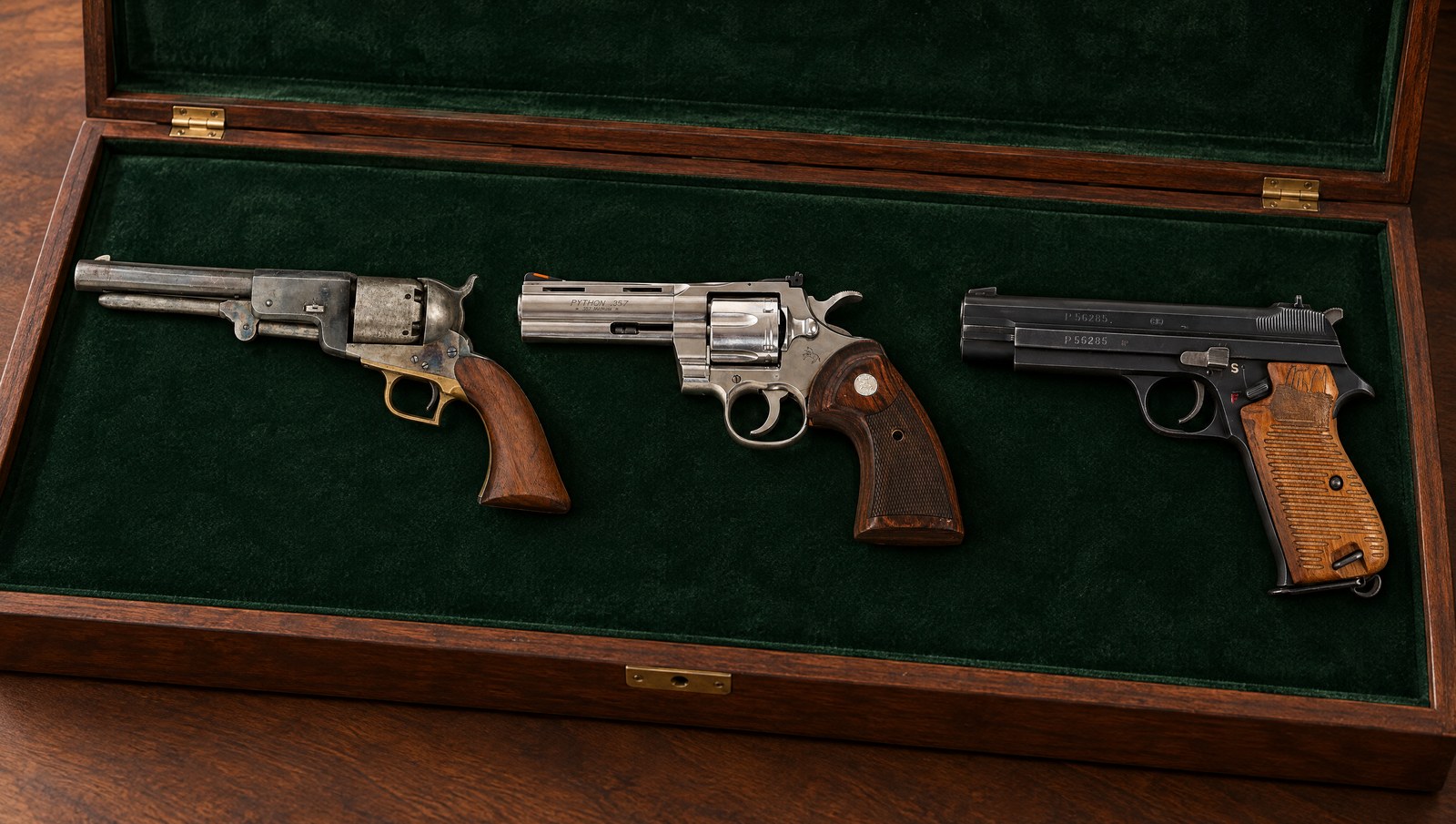 Grail guns: a Colt Walker, a stainless Colt Python and a Swiss SIG P210 in a velvet-lined walnut presentation case