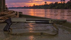 Ithaca Model 37 pump shotgun on the deck of a river patrol boat at dusk