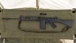 L1A1 self-loading rifle on a green canvas stretcher in a field hospital tent