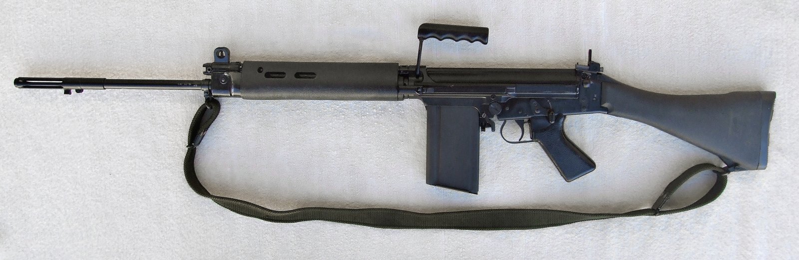 Left side of a British L1A1 self-loading rifle, the inch-pattern FAL, with a folding charging handle and green sling