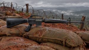 Colt M16A1 rifle with a triangular handguard on sandbags at a Vietnam firebase