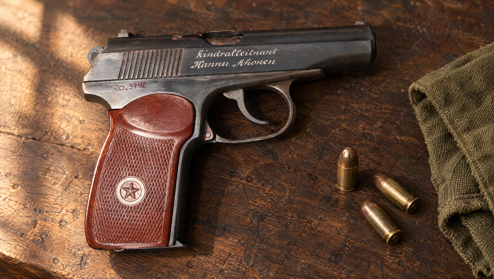 Makarov PM pistol with red-brown Bakelite star grips lying on a walnut workbench beside three 9x18 cartridges