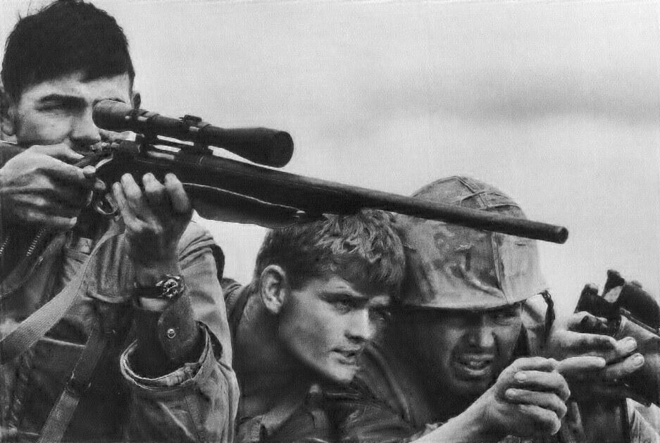 A US Marine Corps sniper and spotters searching for targets in the Khe Sanh Valley around 1968