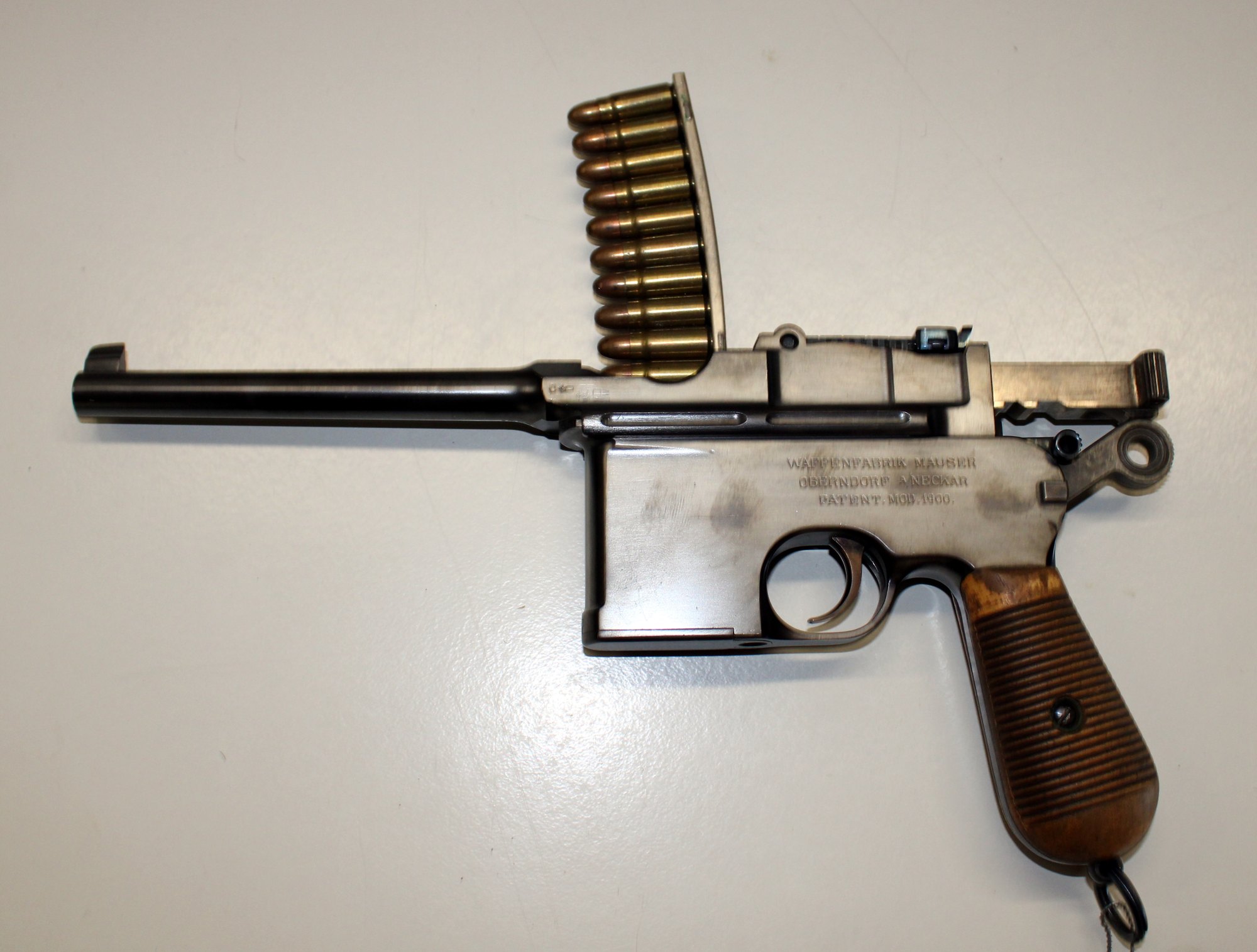 Mauser C96 with its bolt locked open and a 10-round stripper clip of 7.63 mm cartridges in the charger guides