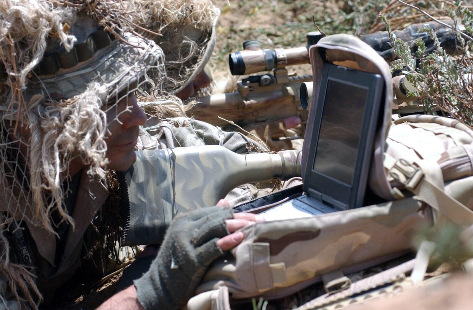 Two camouflaged Navy SEAL snipers on watch, one with a Mk 15 .50 caliber rifle and one with a Mk 11 7.62mm semi-automatic sniper rifle