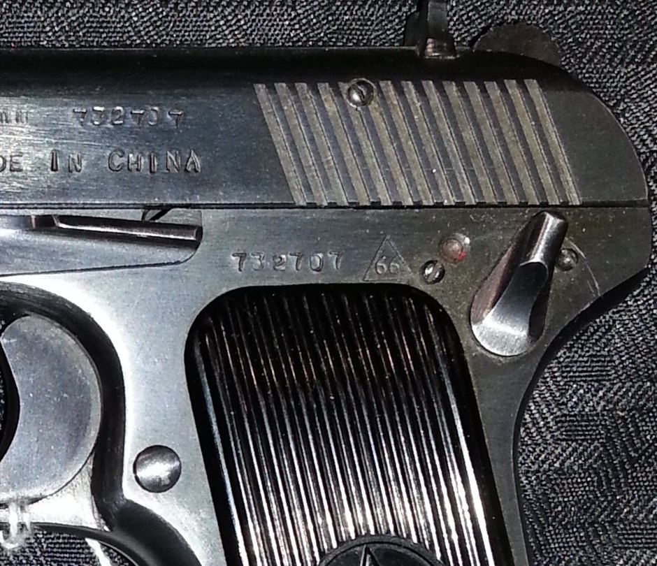 Close-up of a Norinco Model 213 Tokarev showing the frame-mounted safety lever added for export and the Made in China slide marking