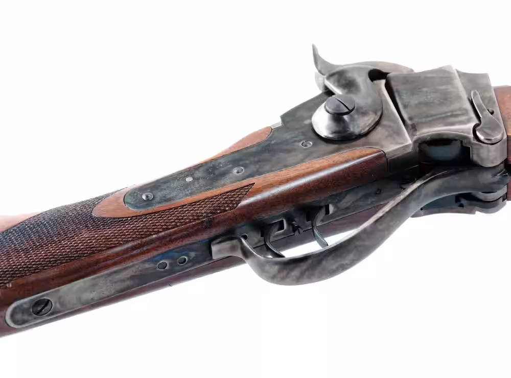 Close-up of a Pedersoli 1874 Sharps color case hardened receiver, lever and double set triggers with checkered walnut wrist