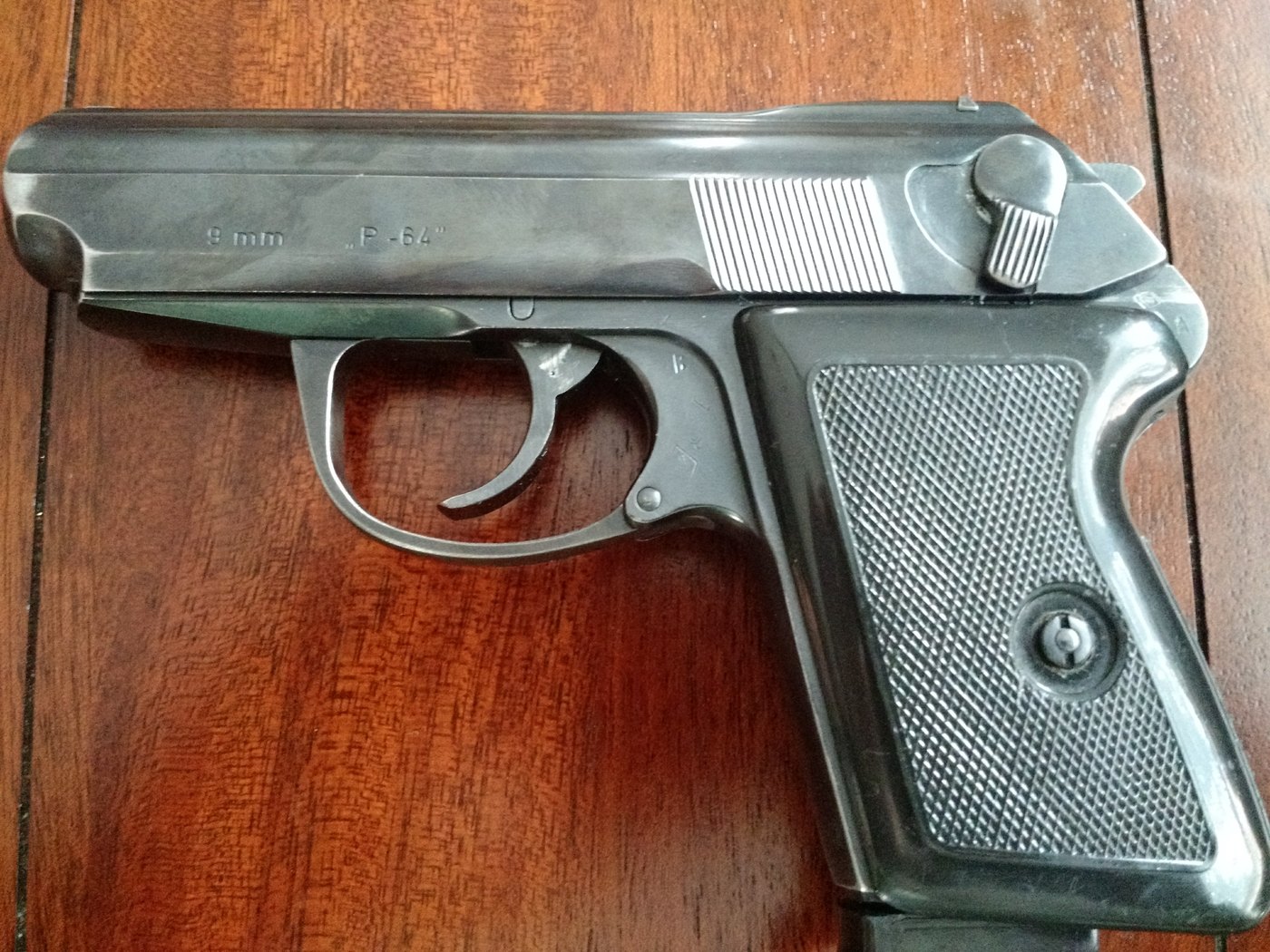 Surplus Polish P-64 pistol in 9x18 Makarov, left side, on a wooden table