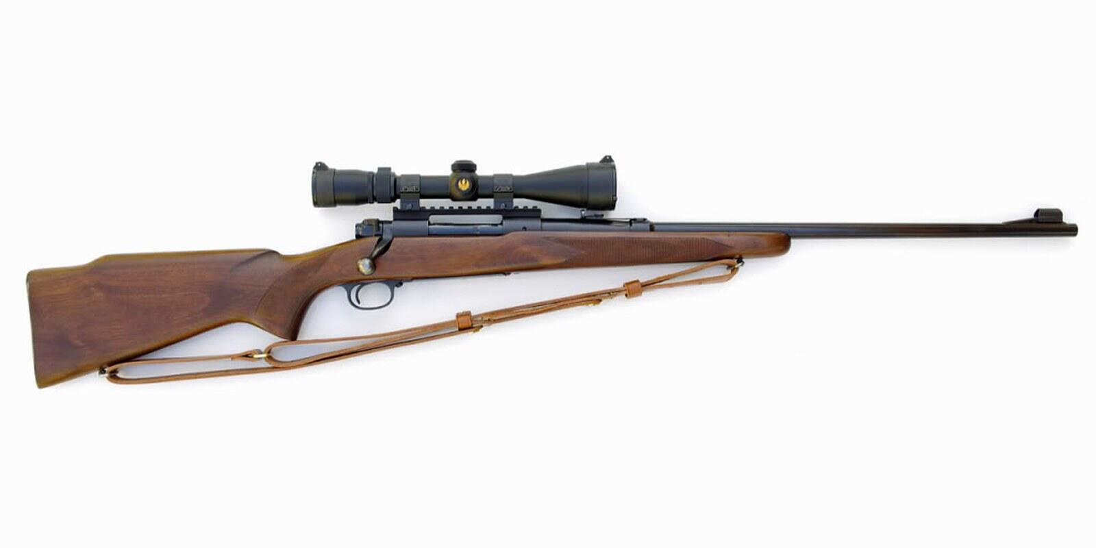 Pre-1964 Winchester Model 70 bolt-action rifle with a walnut stock, scope and leather sling