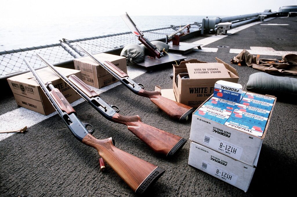 Three Remington 870 Wingmaster shotguns set out for clay target practice on a US Navy ship