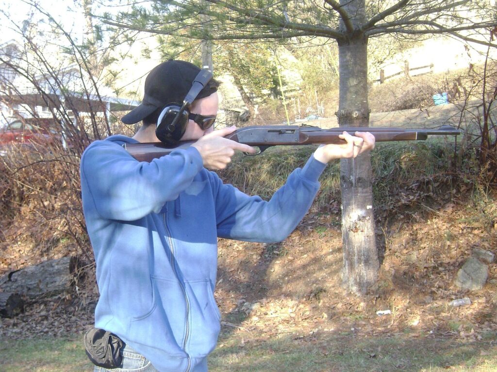 Shooter firing a Remington Nylon 66 .22 rifle with its nylon stock at an outdoor range