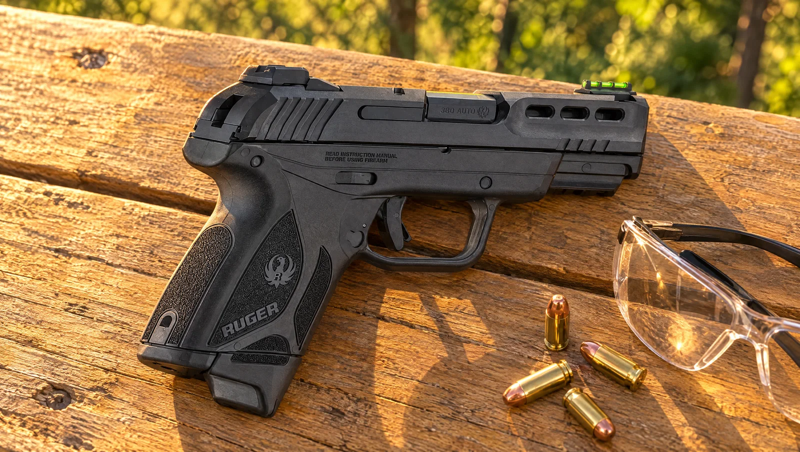 Ruger Security-380 pistol lying on a wooden picnic table in golden evening light next to .380 cartridges and shooting glasses