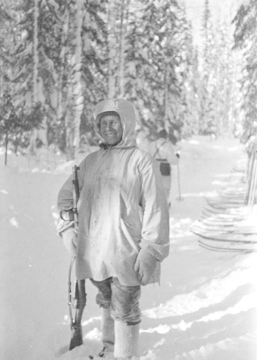 Simo Häyhä standing in deep snow in white winter camouflage with his rifle at Kollaa, 1940
