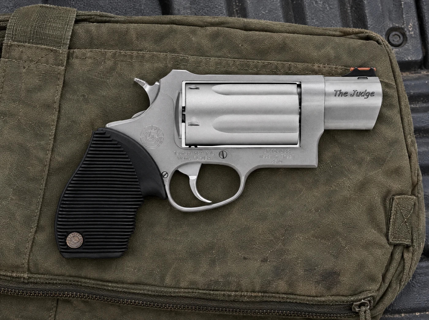 Taurus Judge Public Defender in matte stainless steel on an olive canvas range bag on a truck tailgate